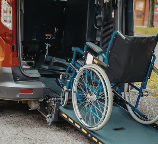 Wheelchair passenger boarding an accessible medical transport van for a scheduled ride in Compton, California